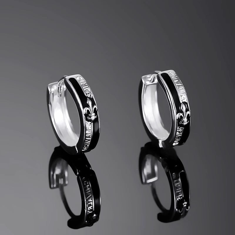 Product photo of stainless steel hoop earrings pair with black enamel inlay and fleur-de-lis design on dark background