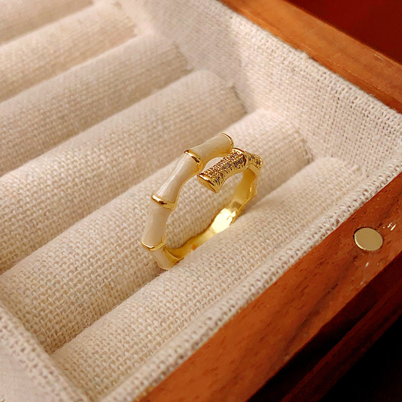 Gold ring with white enamel bamboo design in jewelry box