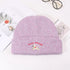 Lavender knit beanie with embroidered white puppy logo on styled product display