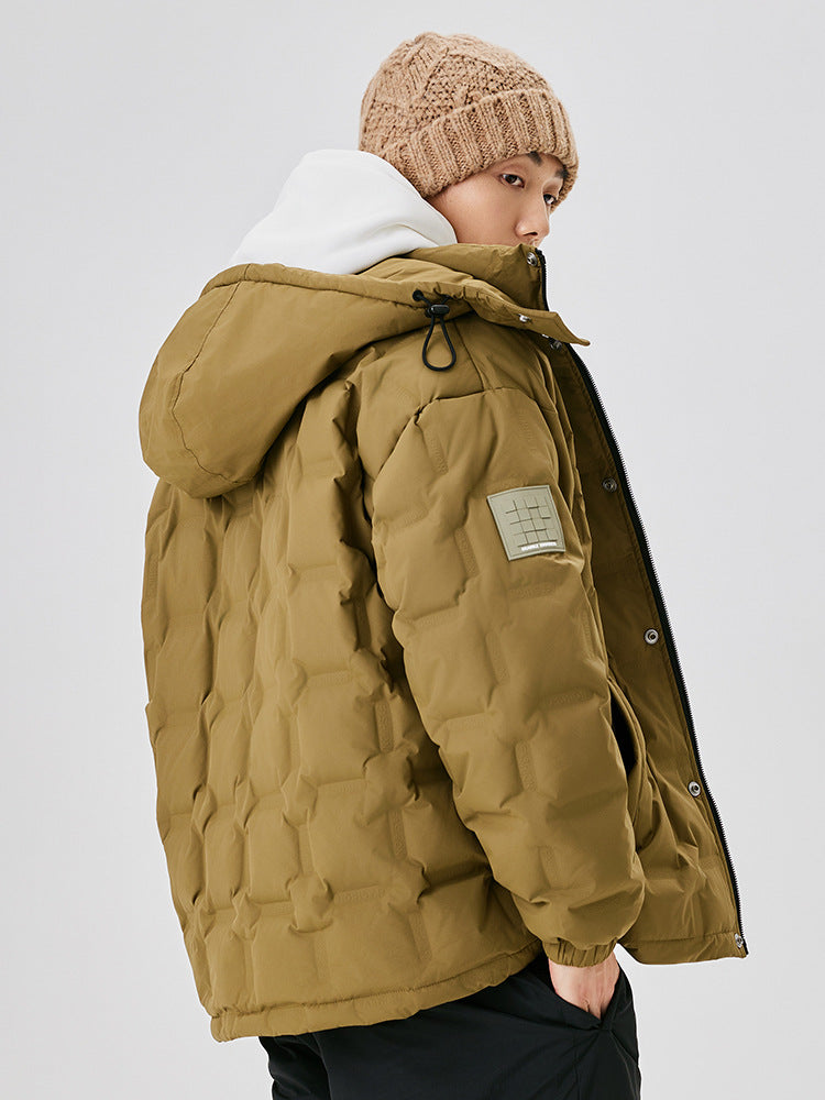 A man in beige knit beanie and olive puffer jacket with white hoodie, photographed from side angle against white background