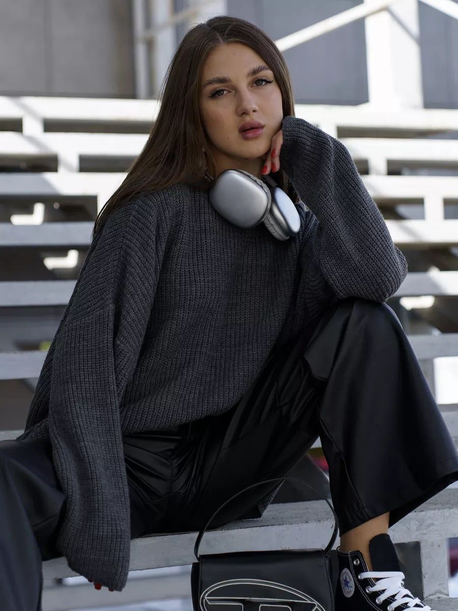 Woman wearing grey knit sweater with silver headphones around neck against geometric background