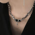 Close-up of silver chain necklace with black stone and star pendant