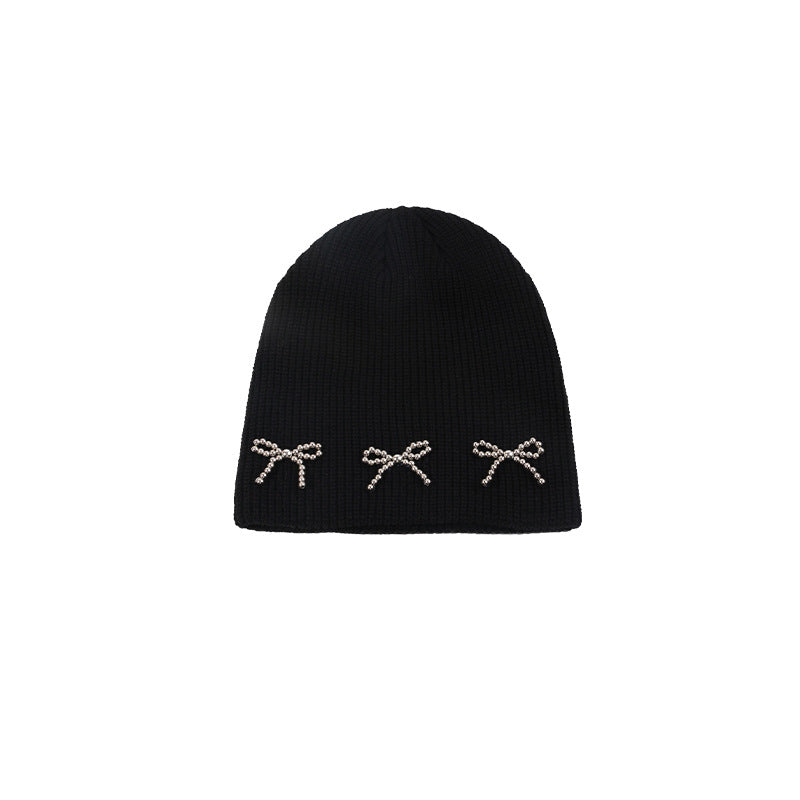 Black knit beanie with three pearl-studded bow decorations in a slightly looser style