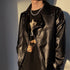 Silver chain necklace styled with black top and printed jacket
