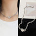 Split image: Silver butterfly necklace worn with white top, and product shot on black background
