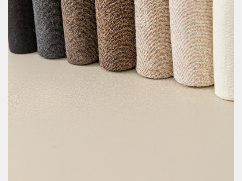 Close-up of knit leg warmers arranged in gradient from dark to light shades