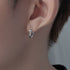 Silver star hoop earring worn on ear