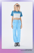 Blue tie-dye crop top with white panel, matching blue jogger pants, and gray sneakers; model wears white rectangular sunglasses