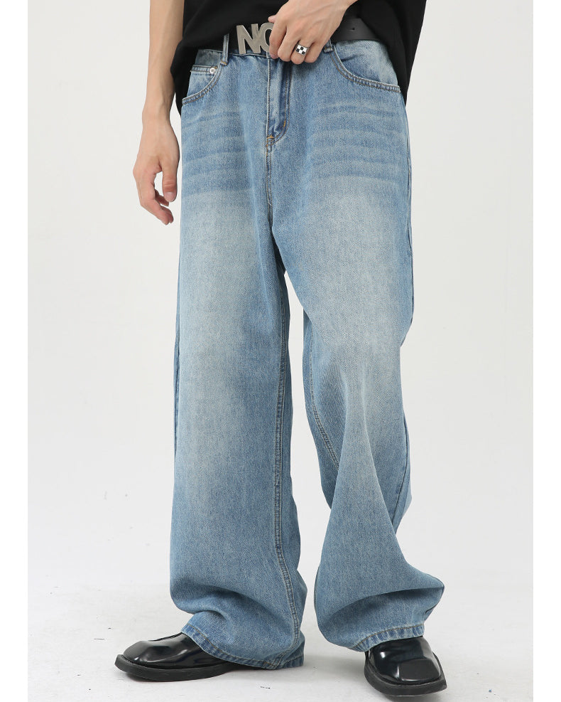 Close-up of light wash wide-leg jeans featuring a 'NOT' belt buckle, styled with black top and patent leather shoes