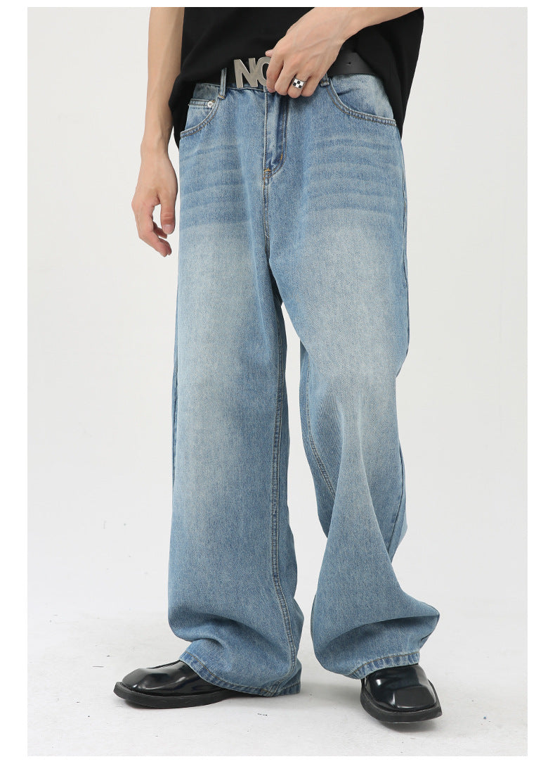 Close-up of light wash wide-leg jeans featuring a 'NOT' belt buckle, styled with black top and patent leather shoes