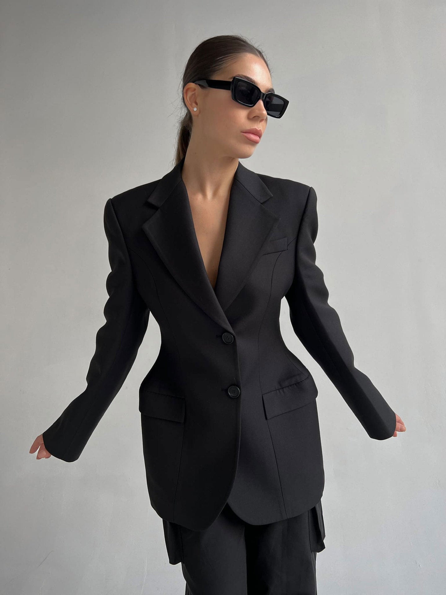 Structured Boss Babe blazer with strong shoulder silhouette and slim waist, styled with black sunglasses for executive look