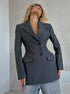 Gray Boss Babe blazer in premium wool blend, featuring sculptural waist and classic notched lapels, editorial styling