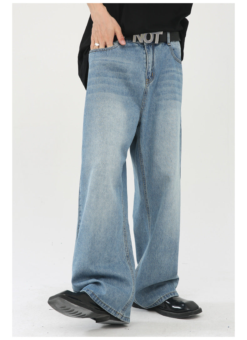 Action shot of light wash wide-leg jeans in motion, showing flowing silhouette with black shoes and oversized top