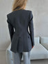 Back view of gray power blazer showing expert tailoring with darted waist and three-button cuff detail, minimalist design