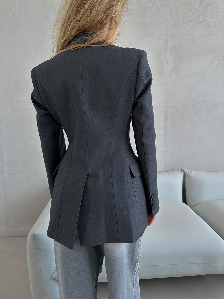 Back view of gray power blazer showing expert tailoring with darted waist and three-button cuff detail, minimalist design