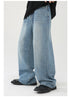 Detail shot of wide-leg denim jeans showing classic straight cut and light wash finish, paired with black loafers