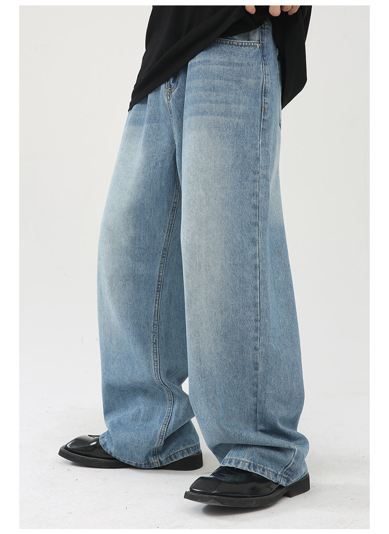 Detail shot of wide-leg denim jeans showing classic straight cut and light wash finish, paired with black loafers