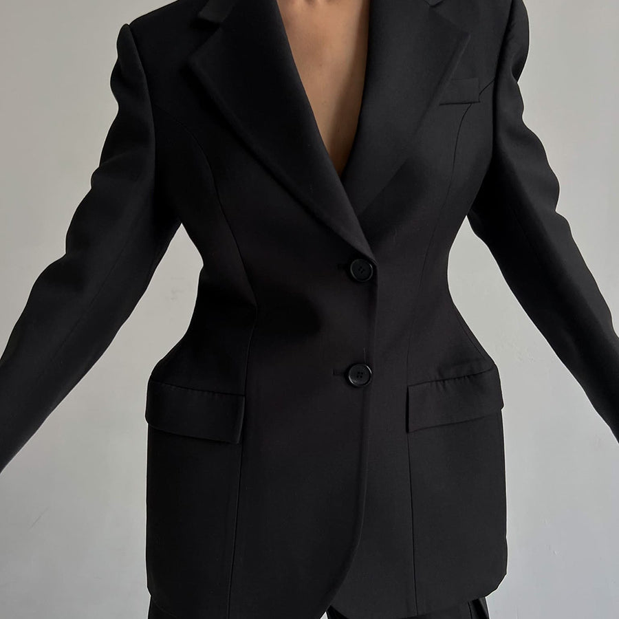 Close-up of black power blazer showing detailed tailoring, flap pockets and hourglass silhouette for professional wardrobe