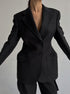 Close-up of black power blazer showing detailed tailoring, flap pockets and hourglass silhouette for professional wardrobe