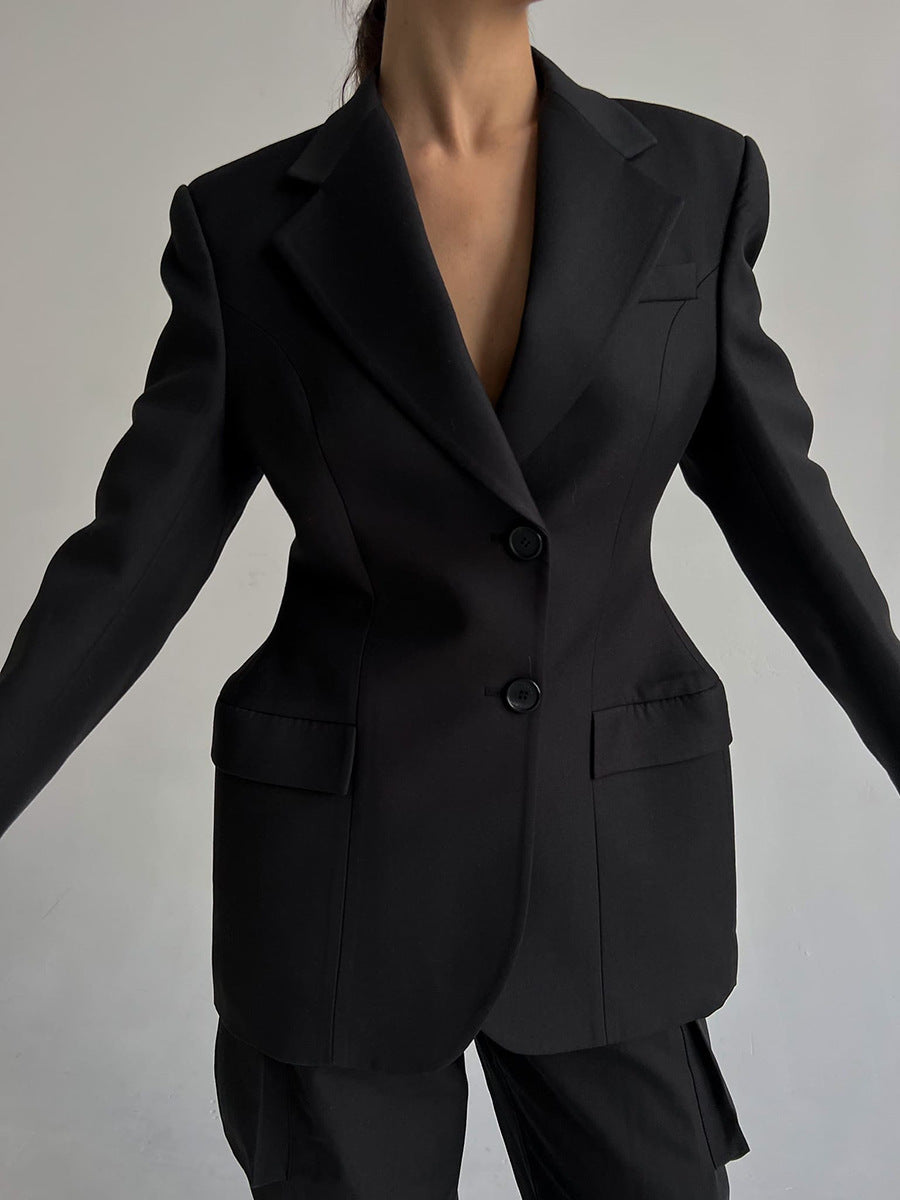 Close-up of black power blazer showing detailed tailoring, flap pockets and hourglass silhouette for professional wardrobe