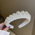Wide pearl-embellished headband in white with graduated pearl sizes