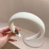 White textured padded headband with 'HANDMADE' label visible