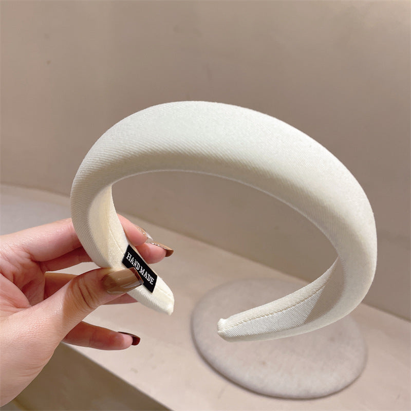 White textured padded headband with 'HANDMADE' label visible