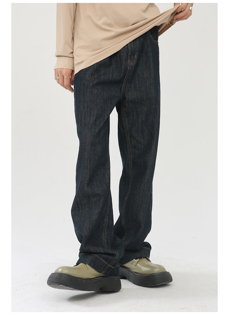 A model is lifting their sweater to show dark denim wide-leg jeans paired with beige oversized top and olive platform shoes