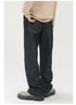 A model is showing the back view of dark indigo jeans with visible back pockets, beige sweater and olive platform shoes against white backdrop