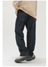 A model is standing in profile wearing dark straight-leg jeans with beige oversized top and olive platform boots against white background