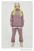 Model with platinum blonde hair and neon green braids wearing a mauve sweatsuit set with hoodie and matching pants, styled with beige sneakers against white background