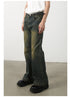 Side profile of wide-leg olive-green jeans showing distinctive seam pattern and faded effects, paired with white top and chunky black shoes