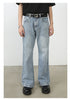 Light wash blue wide-leg jeans with distinctive diagonal seam pattern, classic five-pocket design and straight hem shown on model with designer belt