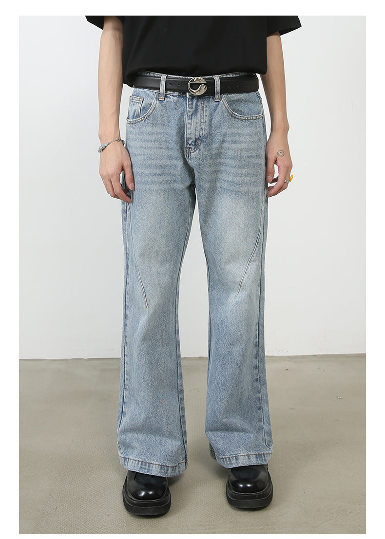 Light wash blue wide-leg jeans with distinctive diagonal seam pattern, classic five-pocket design and straight hem shown on model with designer belt