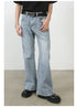 Model wearing light blue wide-leg jeans with unique seam details and faded pattern, styled with black t-shirt and circular logo belt