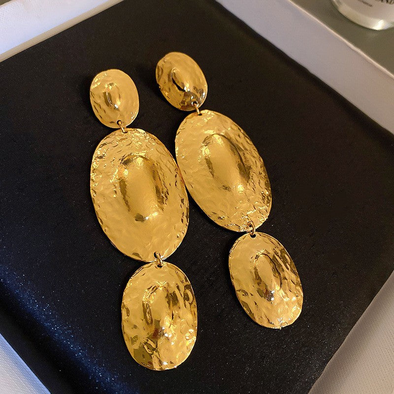 Hammered Gold Dangle Earrings – Long gold dangle earrings with a hammered finish, featuring multiple oval-shaped links, displayed in a jewelry box