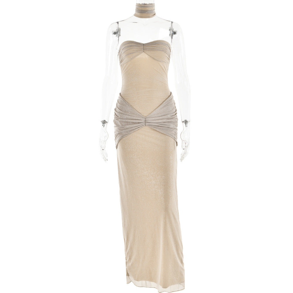 Strapless champagne-colored gown displayed on a transparent mannequin, featuring ruched detailing and a matching choker