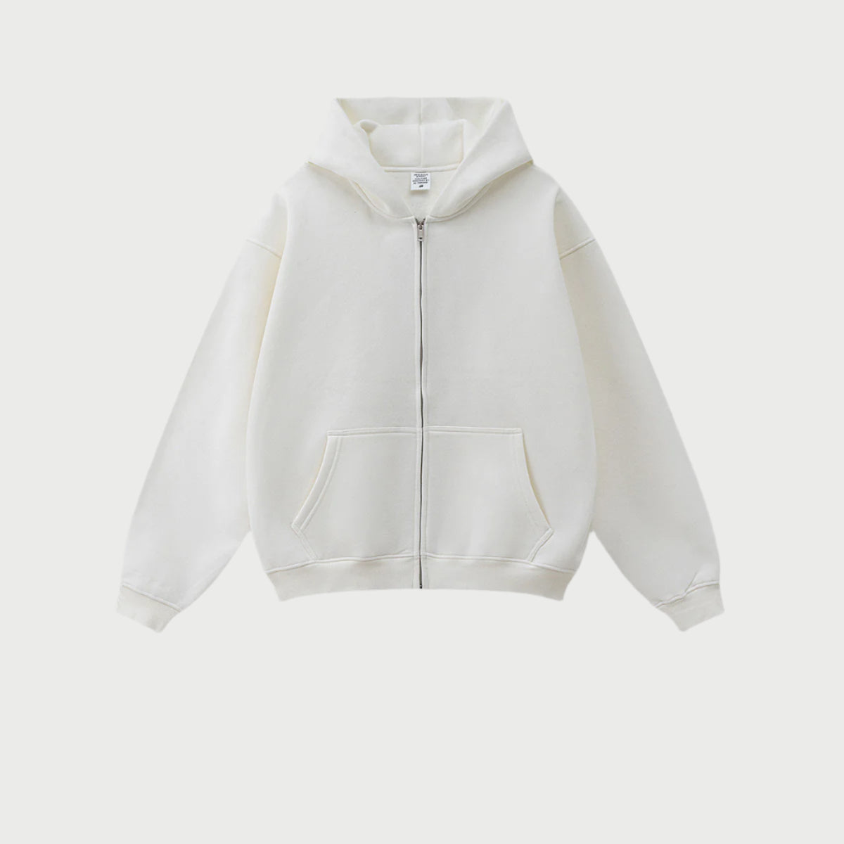 Pure white oversized zip-up hoodie with front kangaroo pocket and ribbed cuffs displayed on light gray background