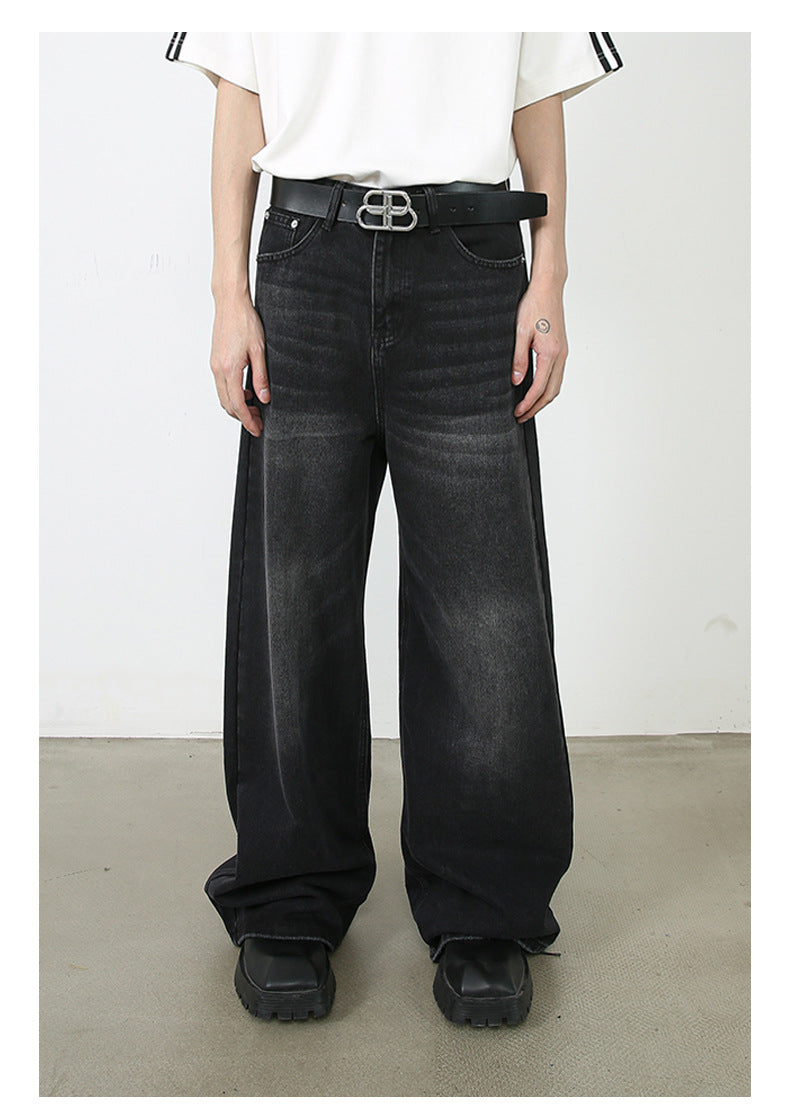 A model wearing a white t-shirt with black stripes on sleeves and ultra-wide black denim jeans with BB logo belt. Features chunky black square-toe shoes