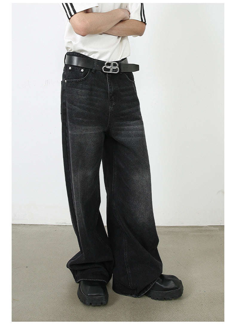 A model with crossed arms wearing white striped t-shirt and high-waisted wide-leg black denim. Features silver BB logo belt buckle and athletic-inspired styling