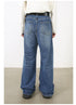 Back view of model in long-sleeve white top and wide-leg medium-wash jeans with black belt and shoes