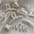 Assortment of white decorative hair clips laid flat, featuring various designs with crystal and star accents