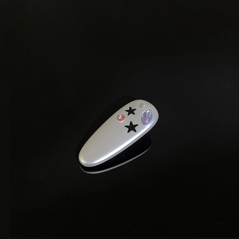 White decorative clip with star and crystal details against black background