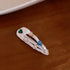 White hair clip with alternating clear and colored crystal heart details