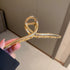 Gold-toned curved hair clip with textured grip design