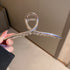 Silver-toned curved hair clip with spring mechanism detail