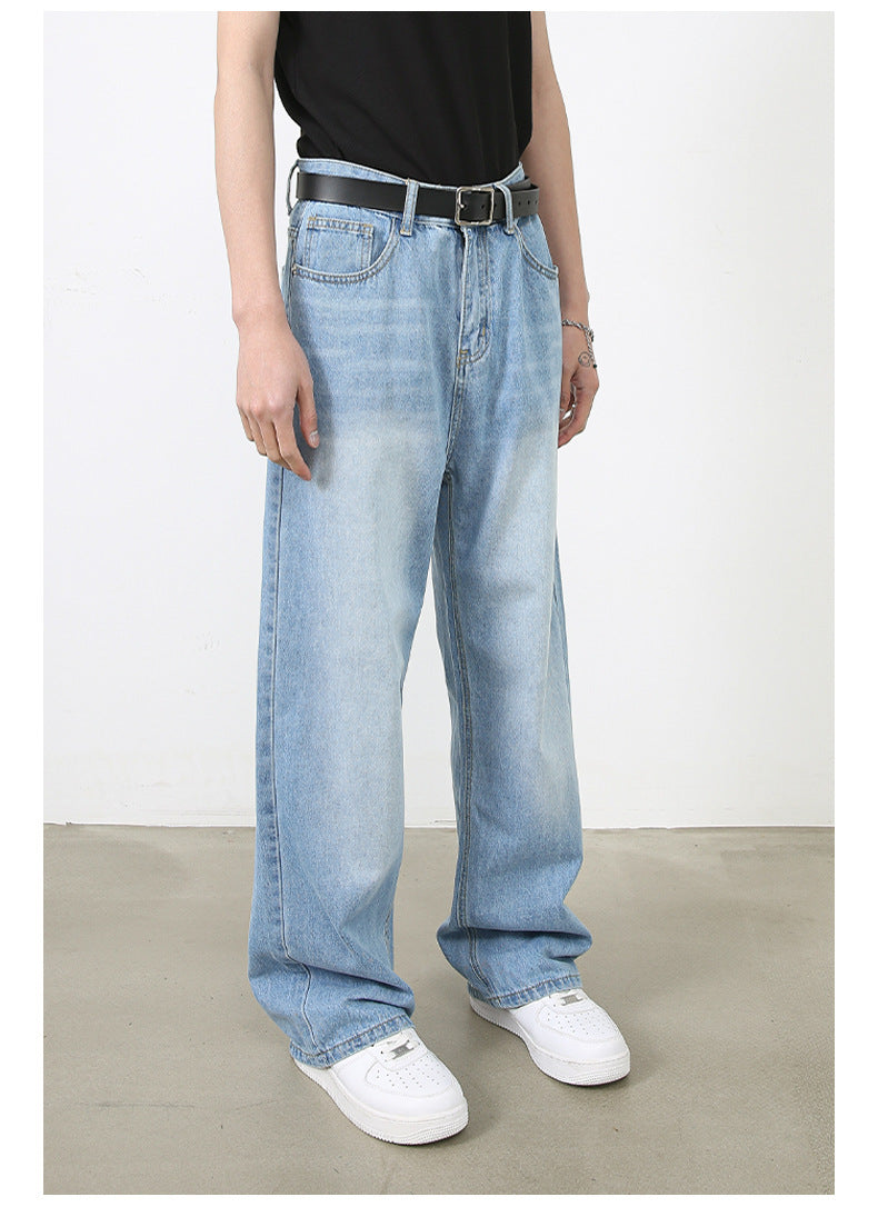 A model is wearing light blue wide-leg denim jeans with a black top and belt, standing in a neutral studio setting