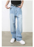 A model is posing with hand in pocket wearing light wash wide-leg jeans, black top and belt against white backdrop