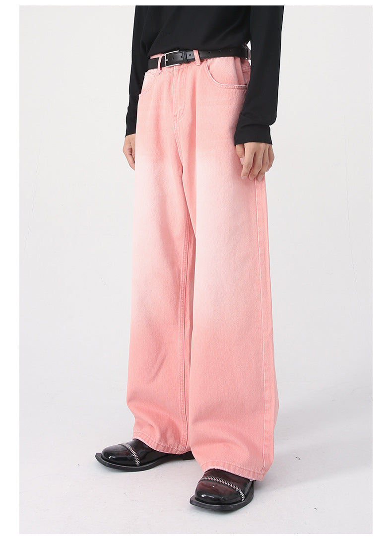 Front view of model wearing pink wide-leg jeans with diagonal seam detail, black belt and shiny black loafers