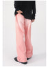 Rear view of model wearing pink loose denim jeans with black top and patent leather shoes against white background
